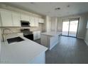Modern kitchen featuring white cabinets, quartz countertops, and stainless steel appliances at 23246 W Miami St, Buckeye, AZ 85326