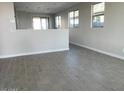 Open living area with wood-look tile flooring and neutral wall colors at 23246 W Miami St, Buckeye, AZ 85326