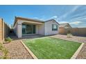 A well-maintained backyard with artificial turf and rock landscaping, perfect for outdoor entertaining at 32034 N 125Th Ave, Peoria, AZ 85383