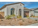 Front exterior of home with rock landscaping, arched window, tile roof, and neutral color scheme at 32034 N 125Th Ave, Peoria, AZ 85383