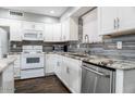 Modern kitchen with white cabinets, granite countertops, and stainless steel appliances at 3331 W Del Monico Ln, Phoenix, AZ 85051