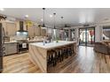 Modern kitchen boasts a large island, stainless steel appliances, and hardwood floors at 38100 W Santa Clara Ave, Maricopa, AZ 85138