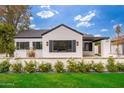 Charming white brick home with black trim, complemented by a well-maintained lawn and a white flower bed at 412 W Vermont W Ave, Phoenix, AZ 85013
