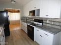 Modern kitchen with white cabinets, granite counters, and stainless steel appliances at 7419 E Abilene Ave, Mesa, AZ 85208