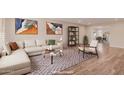 Bright living room featuring a large sectional sofa, modern art, and an open floor plan at 10450 W Campana Dr, Sun City, AZ 85351