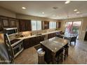 Well-lit kitchen featuring dark cabinetry, granite countertops, and a center island at 15824 S 12Th Way, Phoenix, AZ 85048