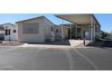 Tan mobile home with covered patio and parking area at 17200 W Bell Rd # 873, Surprise, AZ 85374