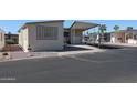 Tan mobile home with covered patio and parking area at 17200 W Bell Rd # 873, Surprise, AZ 85374
