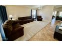 Spacious living room featuring neutral walls and carpeting, with comfortable brown couches and natural light at 2234 E Stephens Rd, Gilbert, AZ 85296