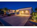 Night view of a two-story home with a three-car garage and mature landscaping at 22819 N Del Monte Dr, Sun City West, AZ 85375