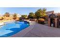Inviting backyard oasis featuring a sparkling pool, outdoor kitchen, and pizza oven at 3057 E Trigger Way, Gilbert, AZ 85297