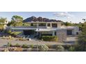 Contemporary home showcasing a modern design with desert landscaping and mountain views at 4451 E Joshua Tree Ln, Paradise Valley, AZ 85253