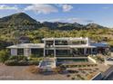 Stunning contemporary home with a pool, set against a backdrop of scenic mountains and desert landscape at 4451 E Joshua Tree Ln, Paradise Valley, AZ 85253