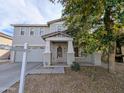 Two-story home featuring neutral stucco, covered entry with columns, and a decorative front door at 6455 W Orchid Ln, Glendale, AZ 85302