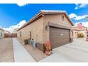 Brown garage door with walkway and landscaping at 830 E Tortoise Trl, San Tan Valley, AZ 85143