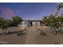 Charming home with desert landscaping, rock lined yard and mature trees under a colorful evening sky at 9410 N 4Th Ave, Phoenix, AZ 85021