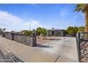 Inviting home with mature landscaping, privacy rock wall, and expansive driveway on a sunny day at 9410 N 4Th Ave, Phoenix, AZ 85021