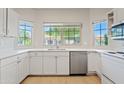 Bright kitchen features white cabinetry, stainless steel appliances, and a garden window above the sink at 955 E Vaughn Ave, Gilbert, AZ 85234