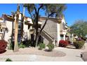 Exterior view of condo building with landscaping and walkway at 9707 E Mountain View Rd # 2430, Scottsdale, AZ 85258