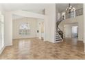 Spacious living room with high ceilings, tile floors, and a curved staircase at 3435 E Desert Trumpet Rd, Phoenix, AZ 85044
