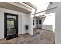 Stylish home entrance with a modern black door, tiled patio, and sleek landscaping features at 9136 N 81St St, Scottsdale, AZ 85258