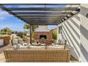 Inviting outdoor patio with pergola, brick fireplace, and comfortable seating, perfect for entertaining at 9136 N 81St St, Scottsdale, AZ 85258