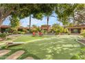 Expansive backyard features a putting green, lounging area, and lush landscaping perfect for relaxation at 11505 E Cochise Dr, Scottsdale, AZ 85259
