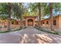 Elegant home with a grand entrance, mature landscaping, and a welcoming walkway at 11505 E Cochise Dr, Scottsdale, AZ 85259