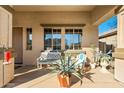 Inviting covered front porch with seating and potted plants, creating a welcoming entrance at 11866 N 143Rd Ave, Surprise, AZ 85379