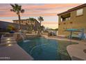 Inviting backyard pool with waterfalls, a built-in grill, and palm trees at 12017 W Monte Lindo Ln, Sun City, AZ 85373