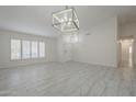 Spacious living room with vaulted ceiling, stylish light fixture and tile floors at 1225 E San Angelo Ave, Gilbert, AZ 85234