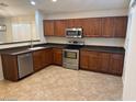 Well-lit kitchen featuring stainless steel appliances, wooden cabinets, and tile flooring at 12848 W Desert Mirage Dr, Peoria, AZ 85383