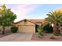 Tan house with tile roof, two-car garage, and desert landscaping at 13830 W Fargo Dr, Surprise, AZ 85374