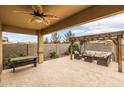 Covered patio features outdoor seating, a pergola, and a ceiling fan at 1437 W Smoke Tree Ave, San Tan Valley, AZ 85140