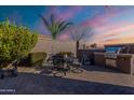 Outdoor dining space with a brick-paved patio, built-in grill, privacy walls, and a desert view at 1808 E Crocus Ave, Queen Creek, AZ 85140