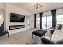 This modern living room features a fireplace, plush seating, large windows, and neutral decor at 34395 N Cherrystone Dr, San Tan Valley, AZ 85144