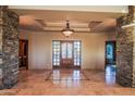 Grand foyer with stone pillars, decorative chandelier, and detailed marble flooring, creating a luxurious entrance at 37870 N 98Th Pl, Scottsdale, AZ 85262