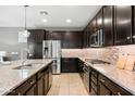 Spacious kitchen showcasing granite countertops, dark cabinetry, and stainless steel appliances at 3833 E Stiles Ln, Gilbert, AZ 85295