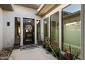 Welcoming front entrance with a decorative door, potted plants, and accent lanterns at 3882 E Andalusia Ave, Gilbert, AZ 85298