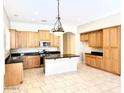 Spacious kitchen with a large island, wood cabinets, black countertops, and stainless steel appliances at 4286 E Buckboard Rd, Gilbert, AZ 85297