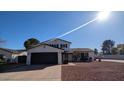 Traditional two-story home boasts a well-maintained front yard, two-car garage, and classic architectural details at 5101 E Winchcomb Dr, Scottsdale, AZ 85254