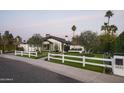 Beautiful home exterior showcasing a lush green lawn, charming picket fence, and well-maintained landscaping features at 6531 N 81St Pl, Scottsdale, AZ 85250