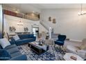 Open-concept living room with soaring ceilings, elegant staircase, and stylish decor at 8534 W Salter Dr, Peoria, AZ 85382
