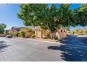 View of the front exterior of the townhouse with mature trees and desert landscaping at 10426 N 10Th St # 1, Phoenix, AZ 85020