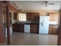 A kitchen featuring tile floors, white appliances, wood cabinets, and a window at 1113 E Bisnaga St, Casa Grande, AZ 85122