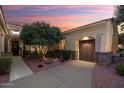 Charming home with a stone accented entrance, two-car garage, and mature landscaping at 13655 W Junipero Dr, Sun City West, AZ 85375