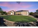 Expansive backyard featuring lush artificial turf and low maintenance desert landscaping at 17591 W Ivy Ln, Surprise, AZ 85388