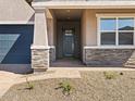A close-up of the front entryway shows stone-accented columns supporting the porch and a blue front door at 17624 W Pierson St, Goodyear, AZ 85395