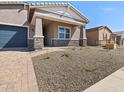 Landscaped front yard leads to a charming single-story home with stone accents and a covered entry at 17624 W Pierson St, Goodyear, AZ 85395