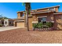 Two-story home featuring desert landscaping, a three-car garage, and a stone-accented facade at 1870 E Indigo Dr, Chandler, AZ 85286